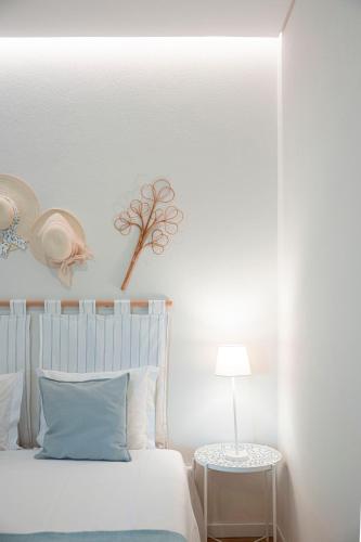 a white bedroom with a bed and a table at Quinta Das Essências in Penafiel