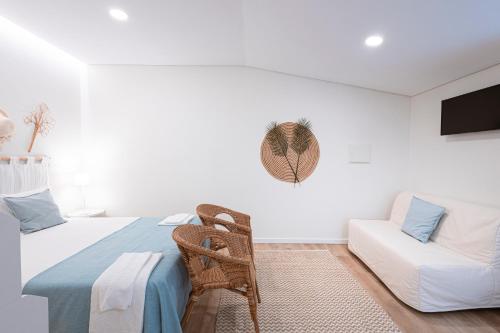 a white bedroom with a bed and a couch at Quinta Das Essências in Penafiel