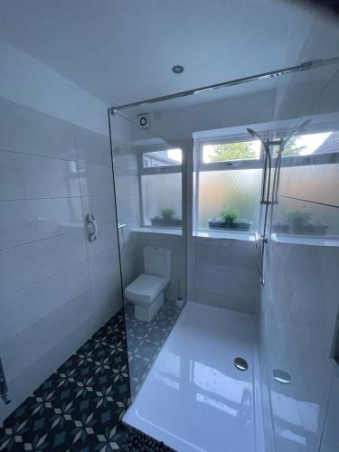 a white bathroom with a shower and a toilet at Horseshoe Forge Plover Cottage Lindley in Huddersfield