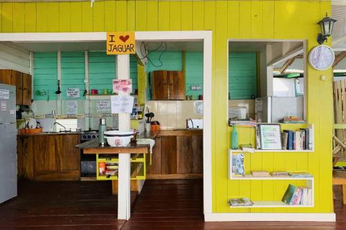 una cocina con una pared amarilla con una mesa. en El Jaguar, en Bocas Town