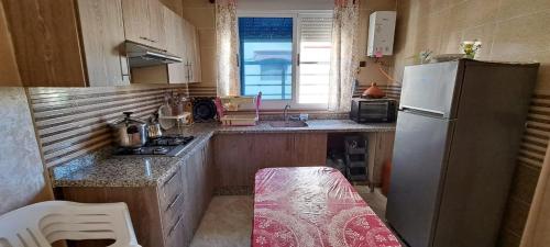 una pequeña cocina con nevera y fregadero en appartement à louer saidia, en Saidia 