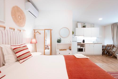 a white bedroom with a bed and a kitchen at Quinta Das Essências in Penafiel