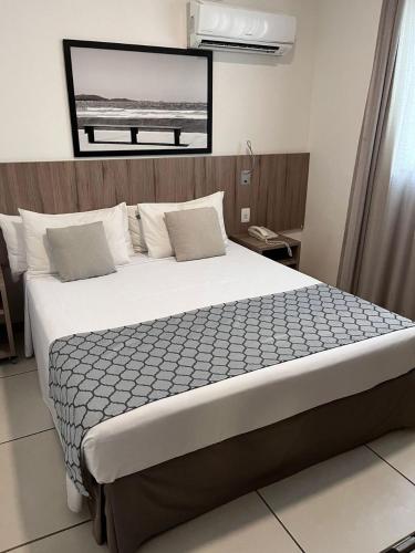 a bedroom with a large bed in a room at Oásis Cabo Frio Hotel in Cabo Frio