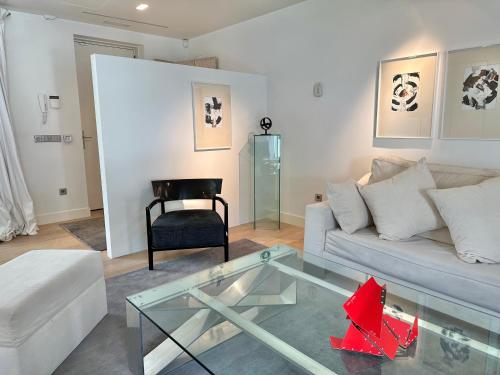 sala de estar con sofá blanco y mesa de cristal en Villa Don Juan en San Sebastián