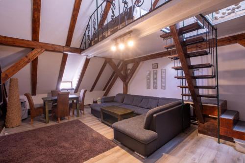 a living room with a couch and a spiral staircase at 4 Rooms Piata Sfatului in Braşov