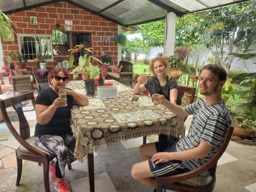 un grupo de personas sentadas en una mesa con bebidas en Cabañas San Diego, en Macas