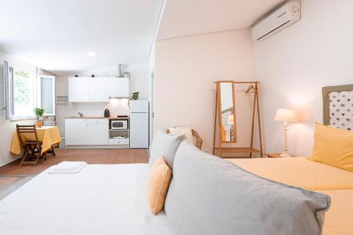 a white room with a bed and a kitchen at Quinta das Essências in Penafiel