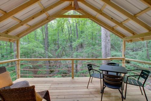 a screened in porch with a table and chairs at 7 Fishing Lure Luxury Glamping Tent Fishing Theme in Scottsboro