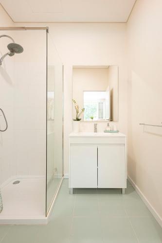 a white bathroom with a sink and a shower at Quinta Das Essências in Penafiel
