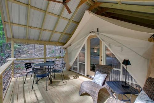 a patio with a table and chairs on a deck at 12 Launch Pad Luxury Glamping Tent Space Theme in Scottsboro