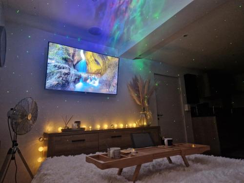 a living room with a tv on a wall with lights at Au Spa de LLEA in Avignon