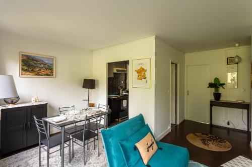 un salon avec un canapé bleu et une table dans l'établissement T3 4P à 5 min Gare RER Univ Paris Saclay et 30 min de Paris Centre, à Orsay