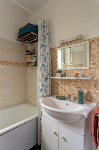 une salle de bain avec un lavabo et une baignoire dans l'établissement T3 4P à 5 min Gare RER Univ Paris Saclay et 30 min de Paris Centre, à Orsay