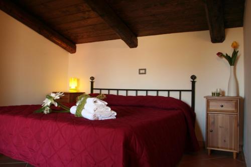 Un dormitorio con una cama roja con un jarrón de flores en Residence Tre Mulini, en Scario