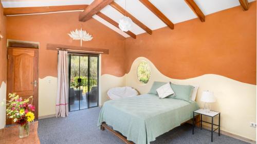 1 dormitorio con 1 cama en una habitación con paredes de color naranja en Casa Samai Boutique en Samaipata