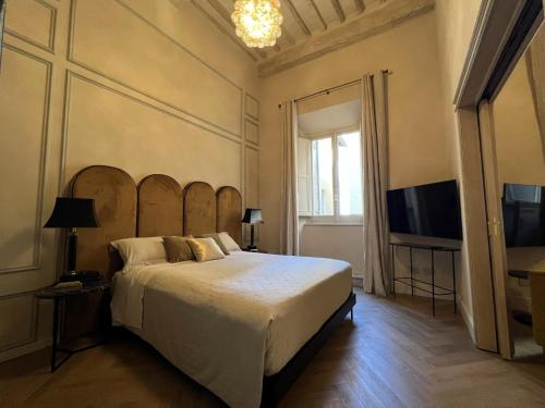 a bedroom with a large bed and a flat screen tv at Casa del Fauno in Montepulciano