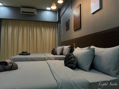 three beds are lined up in a room at Relaxed Studio Q&S-Bed Near Airport WI-FI-Aeropod Sovo in Kota Kinabalu