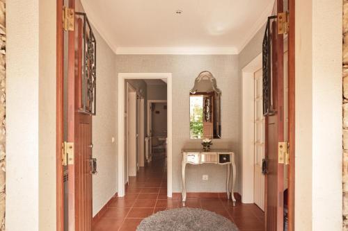 a hallway of a home with a table and a mirror at CASA DA PIA - Pia do Urso in Casais de São Mamede