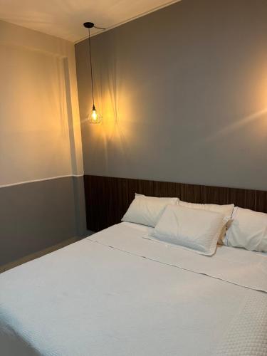 a bed with white sheets and pillows in a room at Sanbru hotel in Zacarias