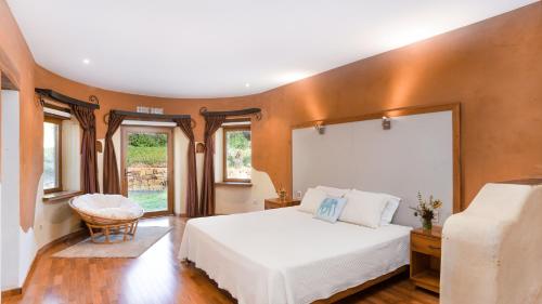 a bedroom with a large white bed and windows at Casa Samai Boutique in Samaipata