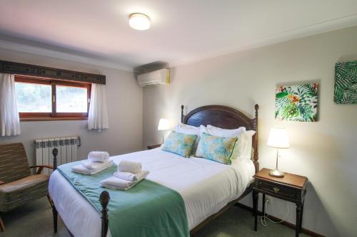 a bedroom with a large bed with towels on it at Cosy Countryside - Family House in Castelo de Paiva