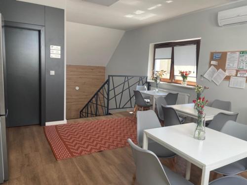 a dining room with tables and chairs and a staircase at Noclegi Budomas Wrocław-Szymanów ParkigFree SmartTv in Wrocław