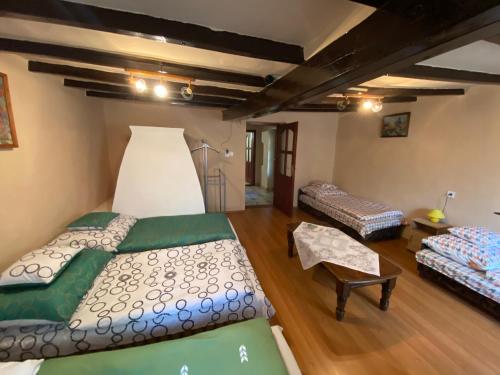 Großes Zimmer mit 2 Betten und einem Tisch in der Unterkunft Emese Vendégház in Tiszafüred