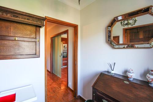 a room with a mirror and a wooden dresser at Cosy Countryside - Family House in Castelo de Paiva