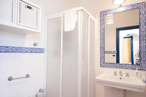 Baño blanco con lavabo y espejo en Villa Blumarine sul mare en San Vito lo Capo