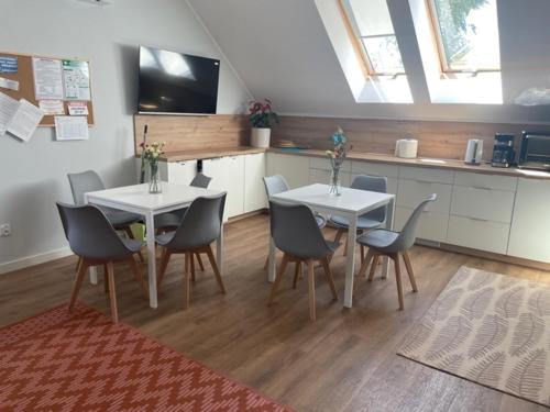 Noclegi Budomas Klima-ParkigFree-SmartTv في فروتسواف: غرفة طعام مع طاولتين وكراسي ومطبخ