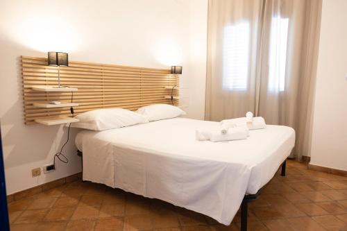 1 dormitorio con 1 cama blanca grande y toallas. en Villa Blumarine sul mare en San Vito lo Capo