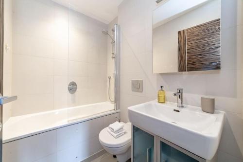 uma casa de banho com um lavatório, um WC e um chuveiro em Spacious Modern One Bedroom Flat in Chelsea em Londres