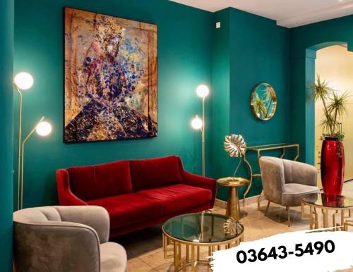 a living room with a red couch and a painting at Boutique-Hotel Amalienhof in Weimar