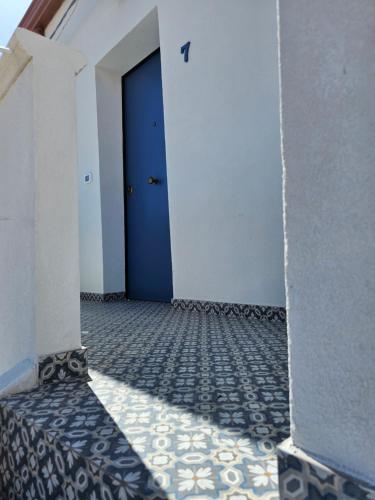 eine blaue Tür in einem Zimmer mit Fliesenboden in der Unterkunft Antico Borgo dei Templi in Agrigento