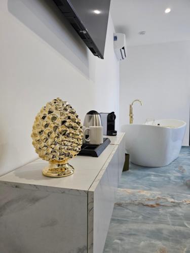 a bathroom with a tub and a table with a sculpture at Antico Borgo dei Templi in Agrigento