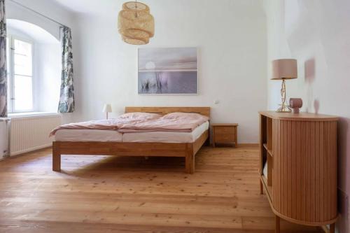 1 dormitorio con 1 cama y suelo de madera en Traumhafte Wohnung für 6 Pers., en Melk
