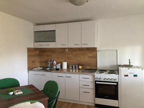 a kitchen with white cabinets and a white refrigerator at Apartman Perper 2 Trebinje in Trebinje