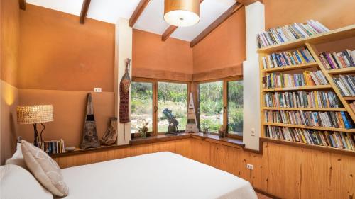 a bedroom with a bed and bookshelves filled with books at Casa Samai Boutique in Samaipata