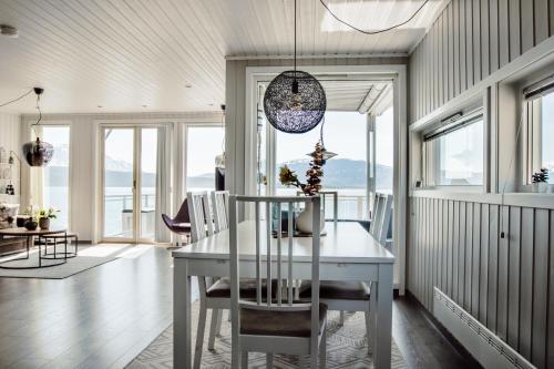 a dining room with a white table and chairs at Malangen Resort in Mestervik