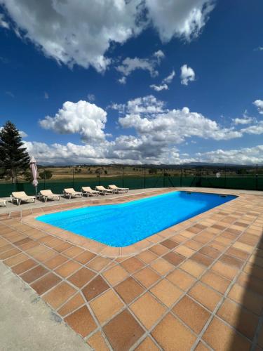 una gran piscina con sillas y un cielo azul en Casa Vella del Cuní en Roda del Ter