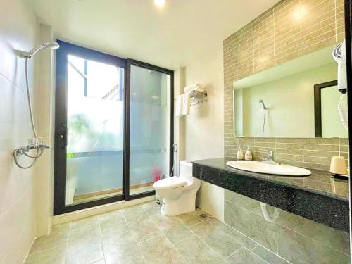 La salle de bains est pourvue d'un lavabo, de toilettes et d'un miroir. dans l'établissement Bai Chay Panda Hotel, à Hạ Long