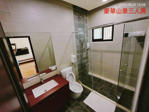 La salle de bains est pourvue de toilettes, d'un lavabo et d'une douche. dans l'établissement Dulan Pearl Hill Homestay, à Donghe