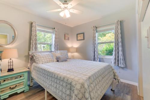 ein Schlafzimmer mit einem Bett und zwei Fenstern in der Unterkunft Charming Sarasota Home with Deck, 3 Mi to Beaches! in Sarasota
