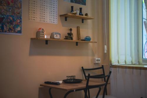 une table et une chaise dans une pièce avec une table et des étagères dans l'établissement Noah Apartment, à Tbilissi