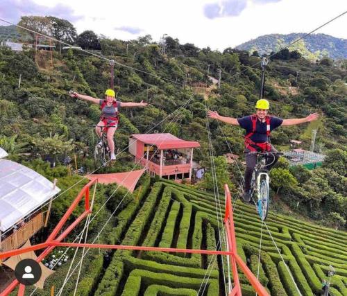 two people riding bikes on a zip line over a field at Cozy 2 bedroom Home 10 min from Airport in San Luis