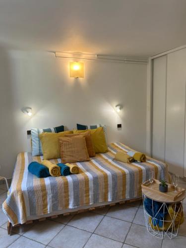 ein Schlafzimmer mit einem großen Bett mit gelben und blauen Kissen in der Unterkunft Beautiful studio + large terrace near the beaches. in Antibes