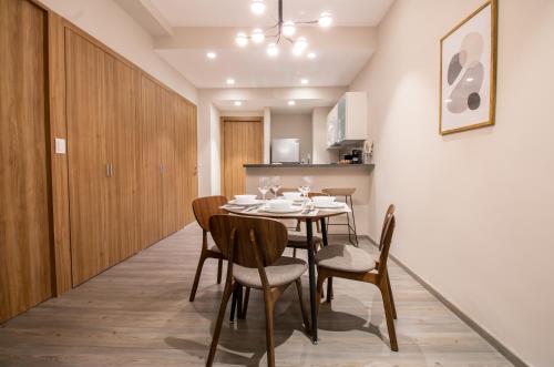 a dining room with a table and chairs at Capitalia Plaza Residences Reforma in Mexico City