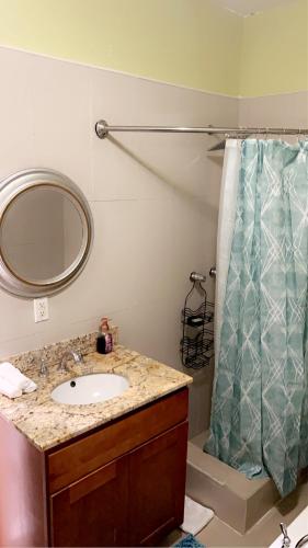 a bathroom with a sink and a shower curtain at Luxury one bed room apartment in Nassau