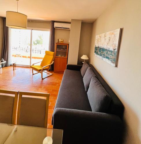 uma sala de estar com um sofá preto e uma cadeira amarela em Torremolinos CARIHUELA Núcleo Cristal em Torremolinos