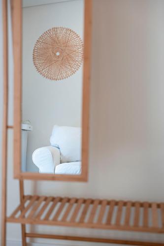 a mirror on a wall with a bench in front at Quinta Das Essências in Penafiel